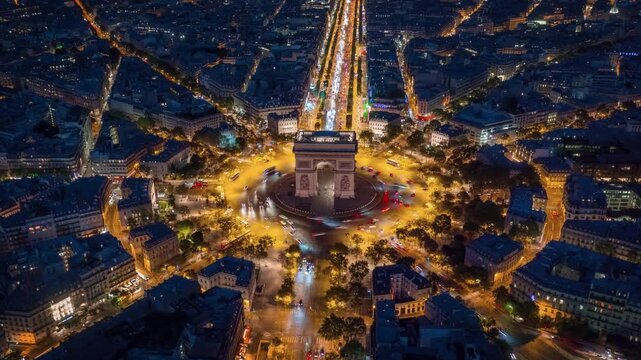 PARIS, FRANCE - OCTOBER 28, 2024: Stunning aerial view of the Arc de Triomphe illuminated at night surrounded by busy city streets