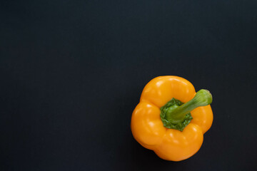 orange bell pepper on black background