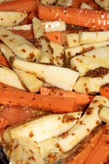 Close Up of Parsnips and Carrots with Honey Mustard Dressing Ready for Roast Dinner