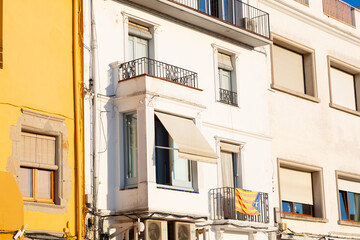 Traditional yellow and white buildings standing side by side under a beautiful blue sky in a small spanish town