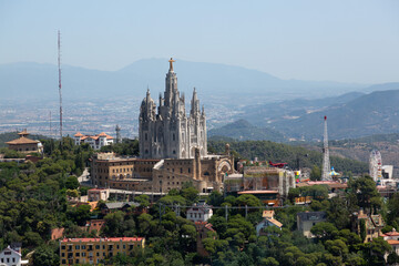 Naklejka premium Tibidabo amusement park and expiatory church of the sacred heart of jesus dominating barcelona cityscape