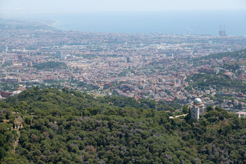 Barcelona cityscape expanding towards the sea with cargo ships waiting in the harbor