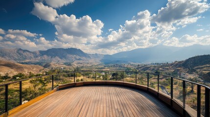 Obraz premium Scenic viewing platform overlooking majestic mountains under a blue sky with clouds and expansive natural landscape in the background