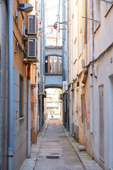 Fototapeta premium Narrow street leading to archway in spanish town
