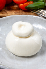 Cheese collection, fresh soft white burrata cheese ball made from mozzarella and cream from Apulia, Italy, close up