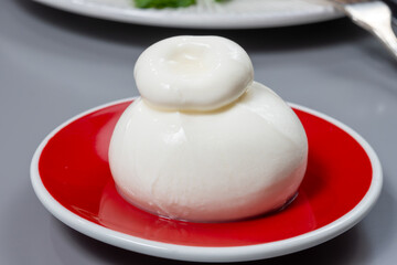 Cheese collection, fresh soft white burrata cheese ball made from mozzarella and cream from Apulia, Italy, close up