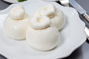 Cheese collection, fresh soft white burrata cheese ball made from mozzarella and cream from Apulia, Italy, close up
