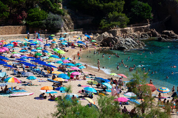Tourists relaxing on the picturesque beach of aiguablava, costa brava, spain