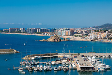 Blanes cityscape with harbor, beach and sa palomera rock in summertime