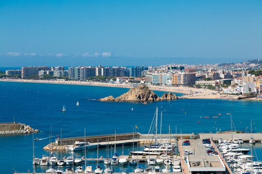 Blanes cityscape with harbor, beach and sa palomera rock in summertime