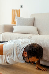 A 50-year-old man doing a fitness workout at home, including strength exercises with resistance...