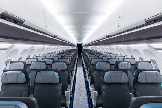 Inside view of empty airplane cabin with modern cabin interior in economy class