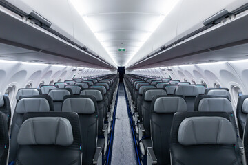 Economy class airplane cabin view with empty seat rows