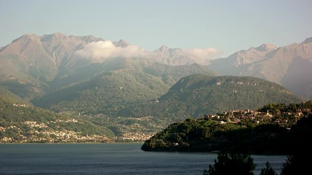 A locked off shot other to the top side of Lake Como showing Olgiasca and Gravedona ed Uniti across the lake. On the mountains tops the other side of the lakes there are some low level clouds.