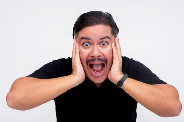 Shocked man expressing surprise with hands on face against white background