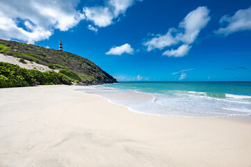 Lighthouse is on a hill overlooking the ocean