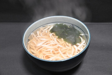 手作りの温かいわかめうどん　日本の家庭料理　黒背景