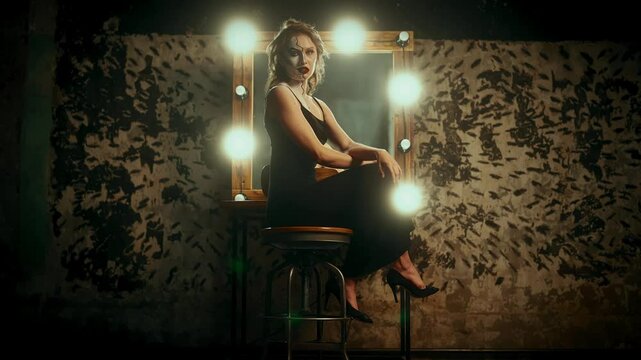 Sexual woman with art makeup on half of face sitting on tall chair, portrait. Madness and beauty, attractive female person posing and smiling to camera, duality of personality, hiding her true self