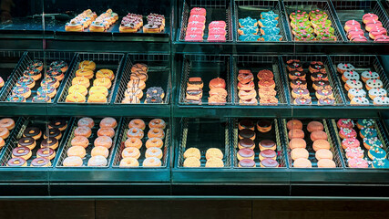 Display case filled with colorful donuts of various shapes and decorations