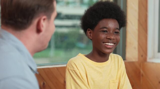 African boy sitting in circle while sharing idea, experience to diverse people in group therapy with trust. Happy high school student thinking and learning about mental health problem. Edification