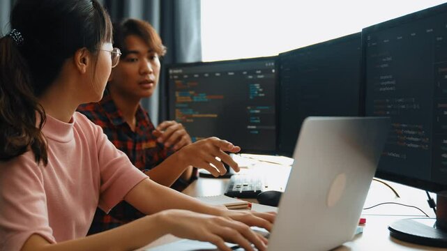 Slow motion back end software developer engineer for computer programming working together on debugging writing computing code, solving complex algorithms display on monitor in office. Burgeoning