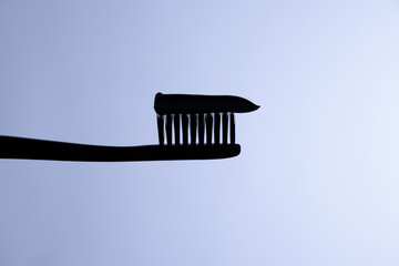 Silhouette of a toothbrush with toothpaste on it. Close up. Shot on a white background.