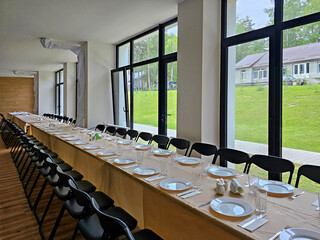 Served long table in a large dining room. Cutlery on the table. Wedding table without guests. Hall for ceremonial banquets on the occasion of important events for a large group of people