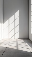 Fototapeta premium Bright sunlight filtering across white walled interior, casting long shadows on minimalist tiled flooring background
