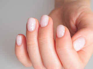 Light and delicate manicure with pastel colors, emphasizing well-groomed nails and an elegant look.