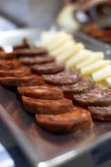 Slices of chorizo and cheese on a serving tray.