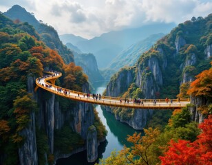 Fototapeta premium Golden bridge spans mountain valley. Tourists walk across bridge. Autumn colors paint mountains and trees. Calm river flows below. Scenic view of Da Nang city in Vietnam. Popular travel destination.