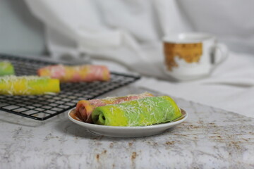 a close up of pancake rolls or Dadar Gulung with a rainbow pattern ready to be served. Food concept photo. Indonesian traditional food.