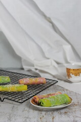 a close up of pancake rolls or Dadar Gulung with a rainbow pattern ready to be served. Food concept photo. Indonesian traditional food.