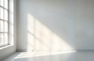 Empty room with bright sunlight casting shadows on white walls. Window in corner provides soft light. Versatile studio space ideal for product presentation. Minimalist design. Modern interior setting.