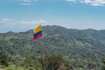 The flag of Colombia with a view over the hills.