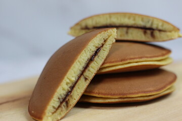 Fototapeta premium Delicious Chocolate Dorayaki Pancakes Stacked on Wooden Board