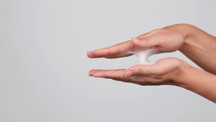 Close-up of hands, soap foam, face foam bubble, baby soap, body hygiene. Product concept, skin care advertising. Femme squeezing white lather on a grey background. Beauty commercial 