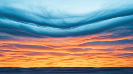 Obraz premium A vibrant sunset featuring layered clouds in blue and orange hues, creating a stunning atmospheric display.