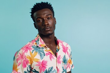 African man in floral shirt posing for camera on vacation.