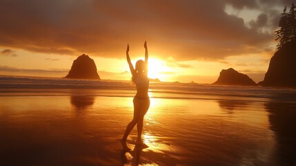 Woman silhouetted at sunset on beach, arms raised.