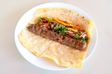 Grilled Turkish Adana, Urfa  Kebab with grilled vegetables, onion and rice on plate. Adana durum, Urfa durum .