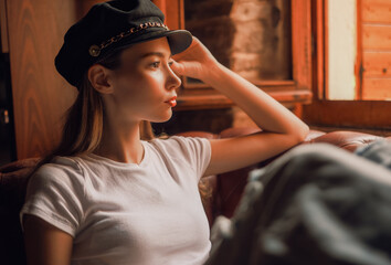 A woman is sitting on a couch with her head tilted to the side