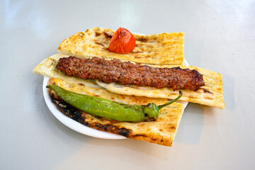 Grilled Turkish Adana, Urfa  Kebab with grilled vegetables, onion and rice on plate. Adana durum, Urfa durum .