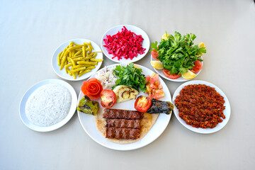 Grilled Turkish Adana, Urfa  Kebab with grilled vegetables, onion and rice on plate. Adana durum, Urfa durum .