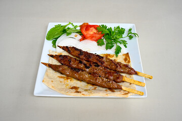 Grilled Turkish Adana, Urfa  Kebab with grilled vegetables, onion and rice on plate. Adana durum, Urfa durum .