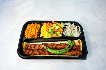 Grilled Turkish Adana, Urfa  Kebab with grilled vegetables, onion and rice on plate. Adana durum, Urfa durum .