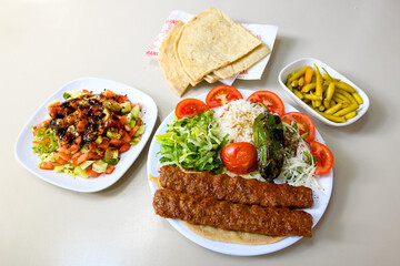 Grilled Turkish Adana, Urfa  Kebab with grilled vegetables, onion and rice on plate. Adana durum, Urfa durum .