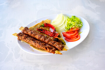Grilled Turkish Adana, Urfa  Kebab with grilled vegetables, onion and rice on plate. Adana durum, Urfa durum .