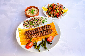 Grilled Turkish Adana, Urfa  Kebab with grilled vegetables, onion and rice on plate. Adana durum, Urfa durum .