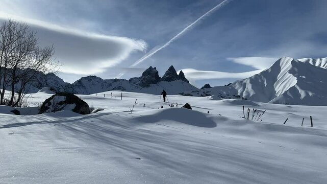 man doing ski mountaineering in front of the aiguilles d'arves; man alone in a winter landscape with fresh snow